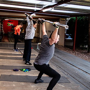 a group of people doing a workout with overhead movements